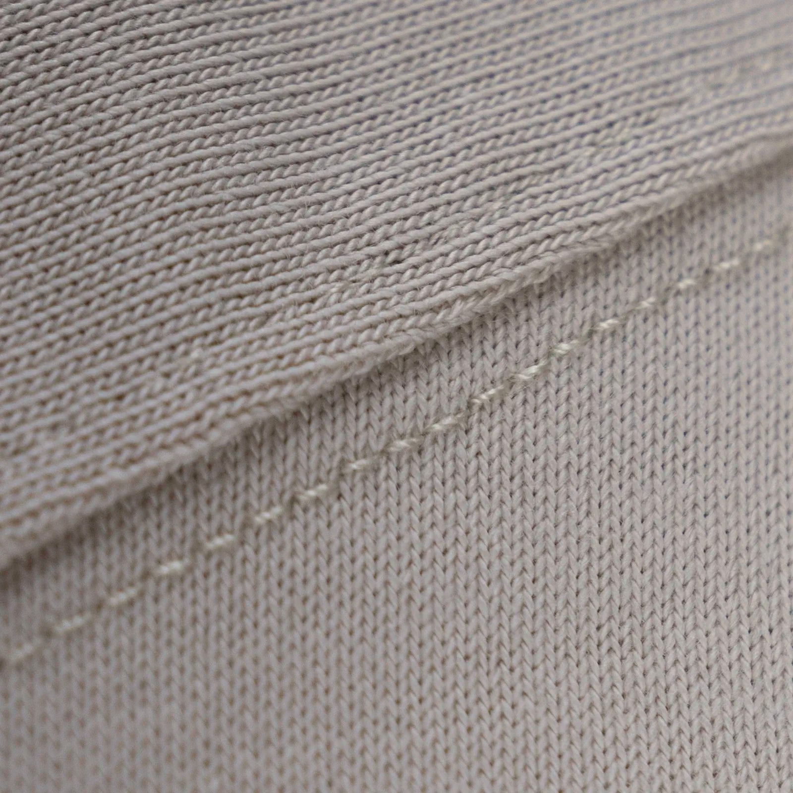 Zoomed fabric texture showing dense heavyweight cotton knit on a beige tee for everyday durability.