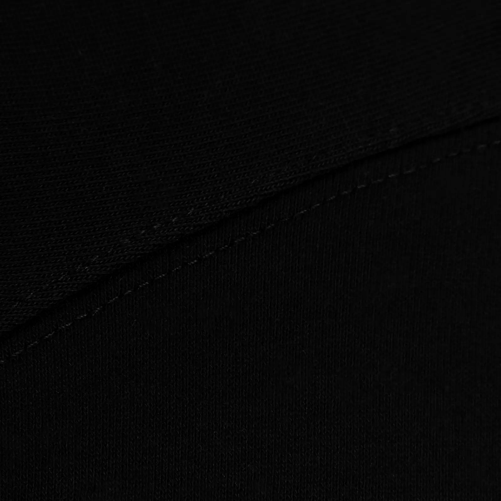Close fabric view of a black heavyweight cotton t-shirt—soft handfeel with a sturdy weave.