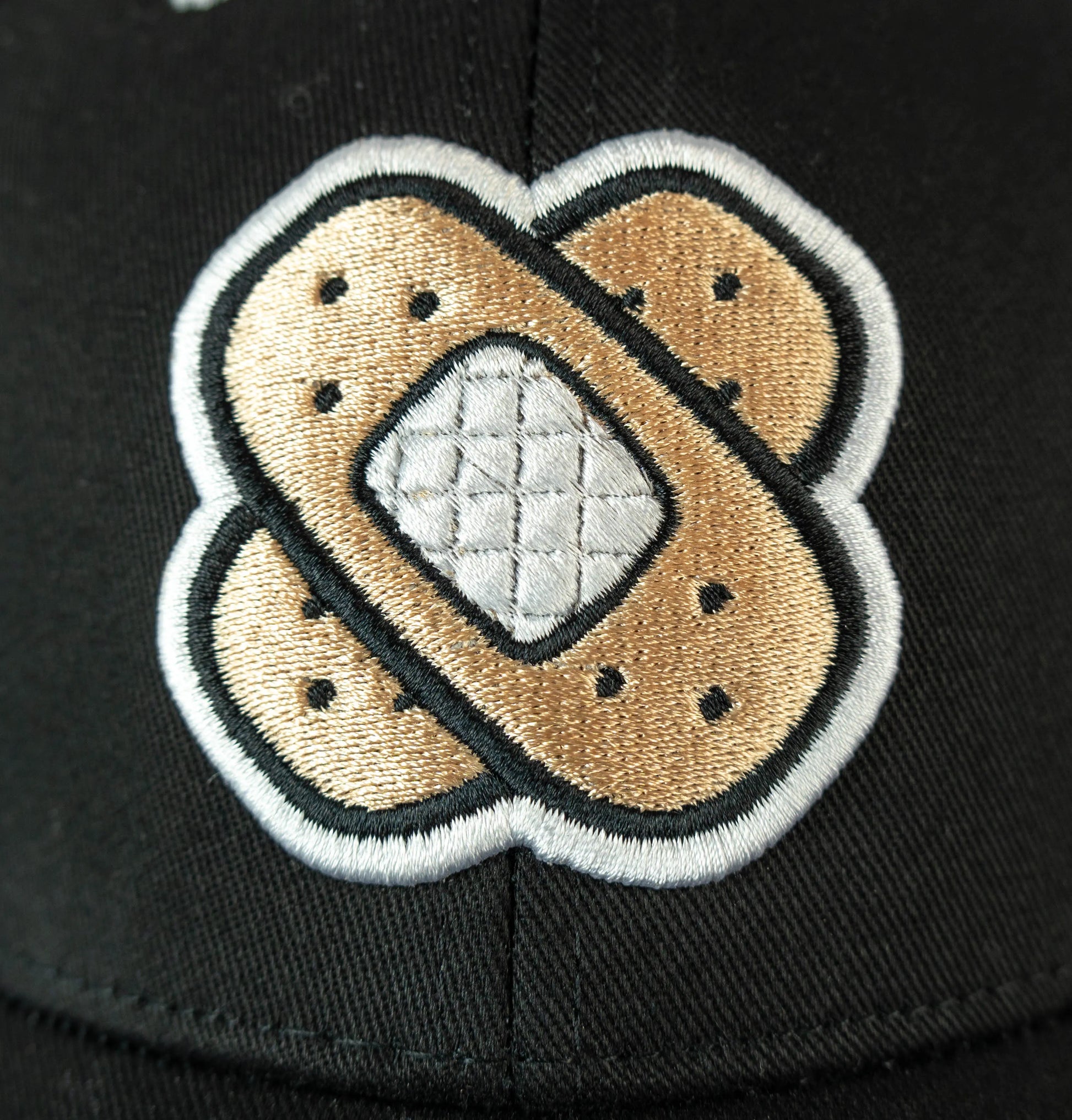 Close-up of bandaid front embroidery on a black adjustable baseball cap—kawaii accessory and furry merch.