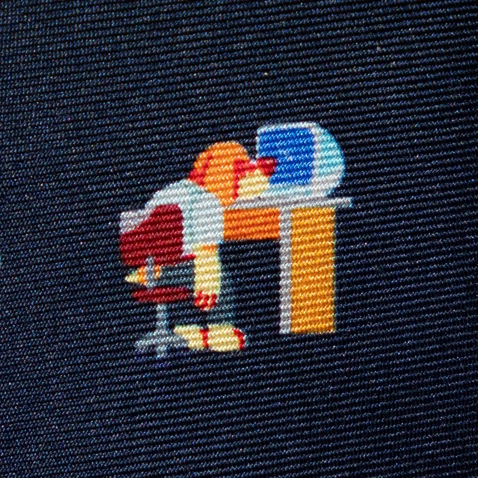 Embroidered design on fabric showing a beagle character looking at a crashed computer at a desk.