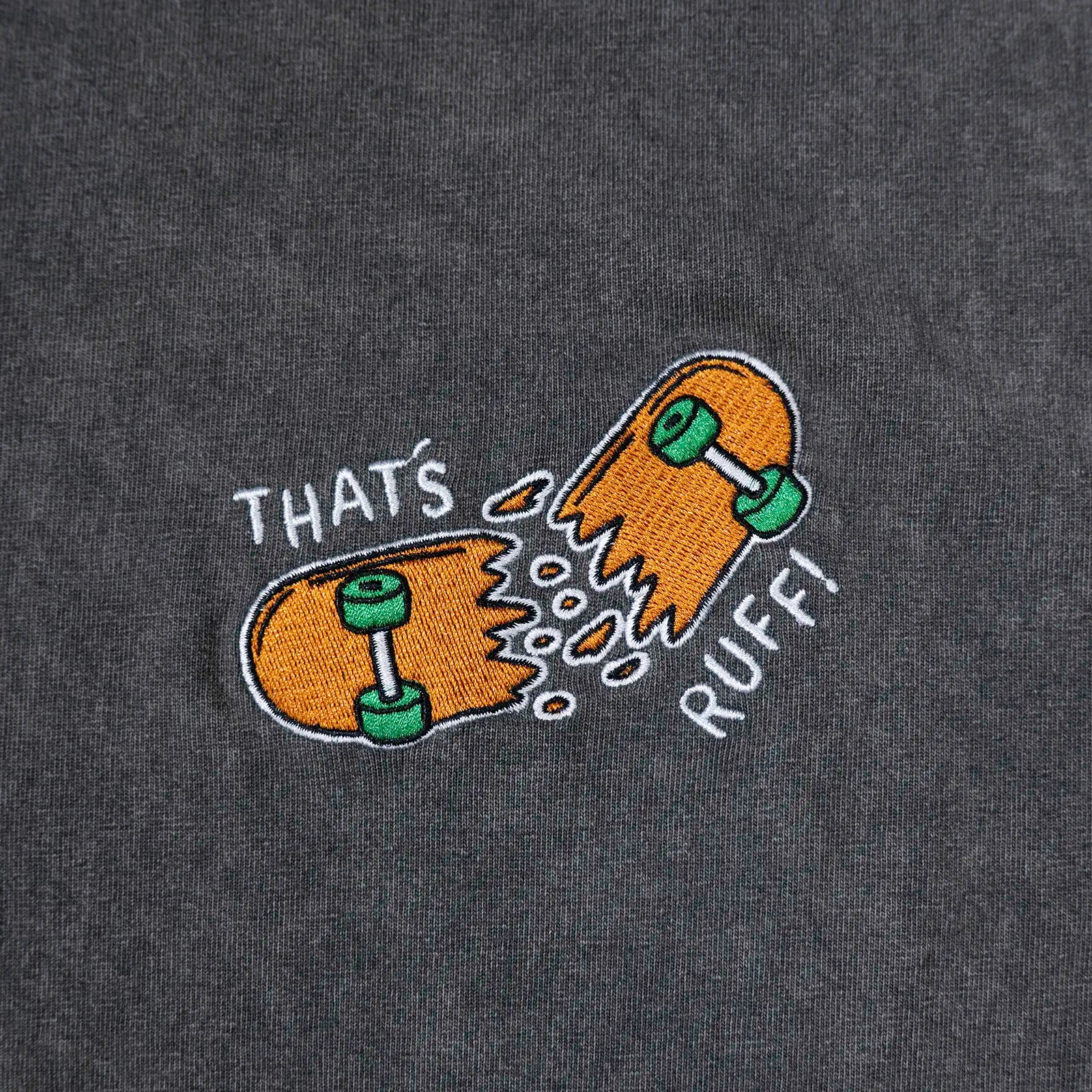 Chest embroidery close-up of the broken-skateboard logo on a grey oversized tee—kawaii skater streetwear for furry clothing fans.