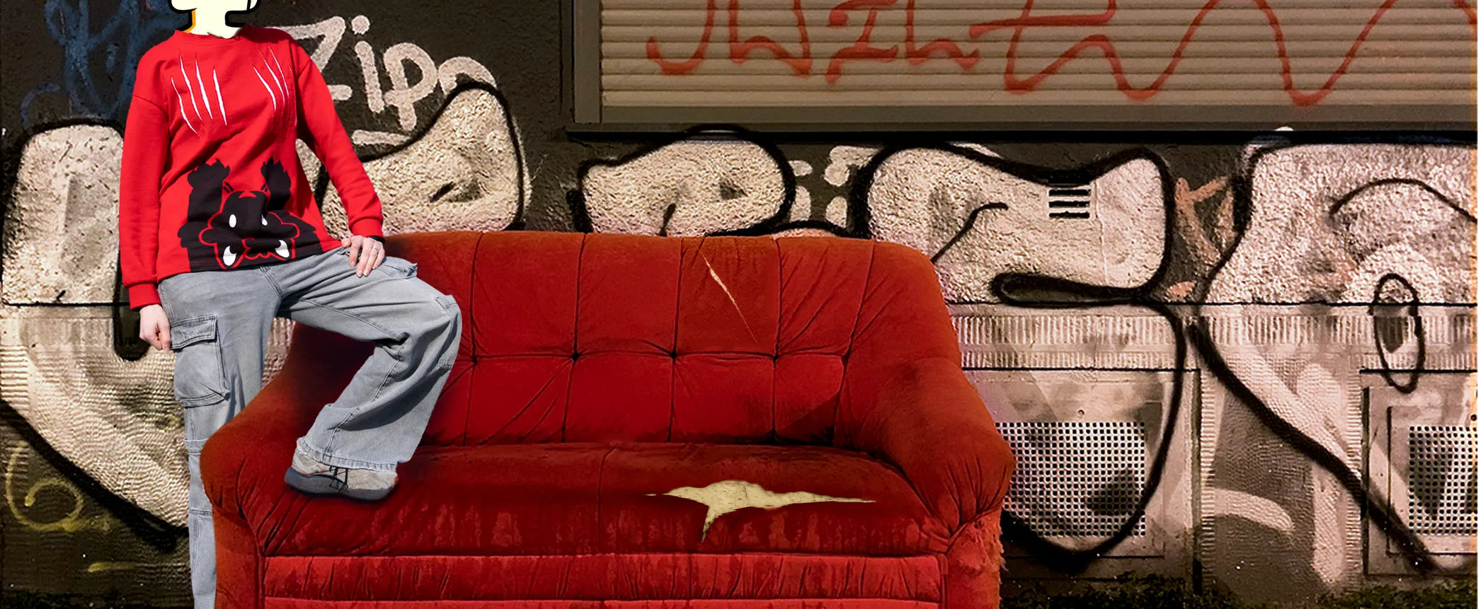 Person wearing a red sweater with black graphics sitting on a red couch against a graffiti-covered wall.slider_item_7eXGai