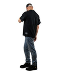 Back view of a model wearing a black t-shirt with the 'That's Ruff!' logo near the hem, paired with jeans and boots. A sleek and casual look from the 'That's Ruff!' collection, showcasing subtle branding and everyday style.