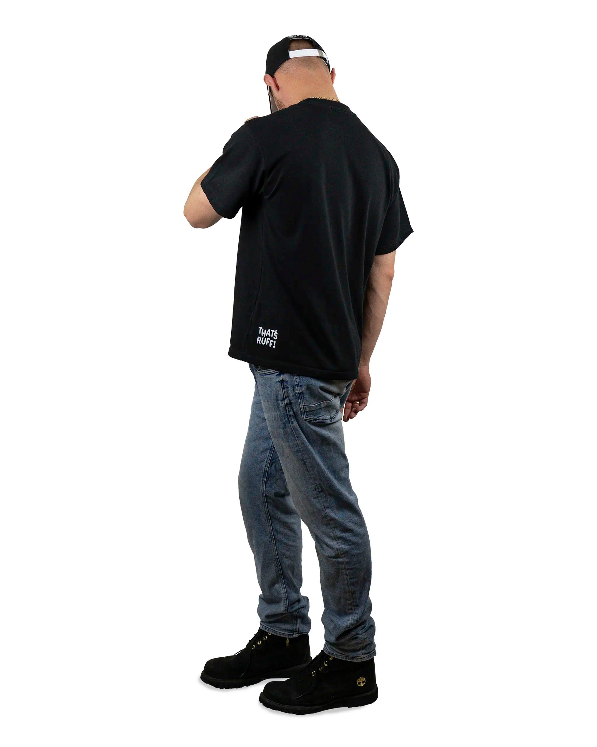 Back view of a model wearing a black t-shirt with the 'That's Ruff!' logo near the hem, paired with jeans and boots. A sleek and casual look from the 'That's Ruff!' collection, showcasing subtle branding and everyday style.