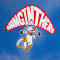 Close-up of the “Hang In There” cat front print on a blue oversized tee—cute kawaii animal furry streetwear/furry clothing brands.