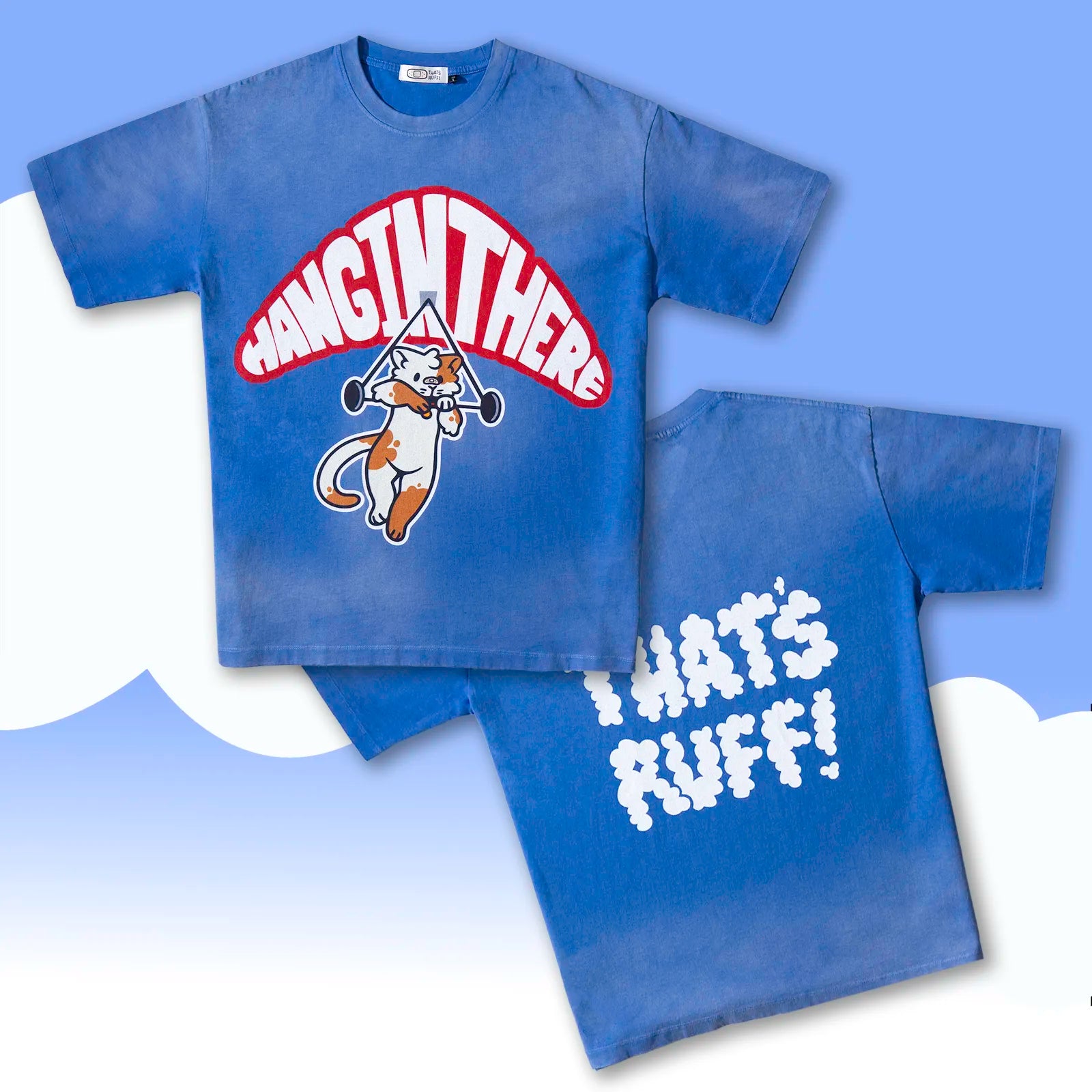 Flat lay showing the cat hang-glider front graphic and THAT'S RUFF cloud logo back on a blue oversized cotton tee—furry streetwear/furry merch.