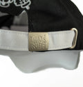 Adjustable black-and-white strapback cap with metal THAT'S RUFF logo clasp—embroidered accessory for furry merch & furry clothing fans.