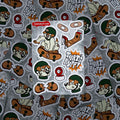 Overhead layout of Ollie sheets on grey; waterproof, UV-safe plant-cellulose stickers for skaters and anthro fans.