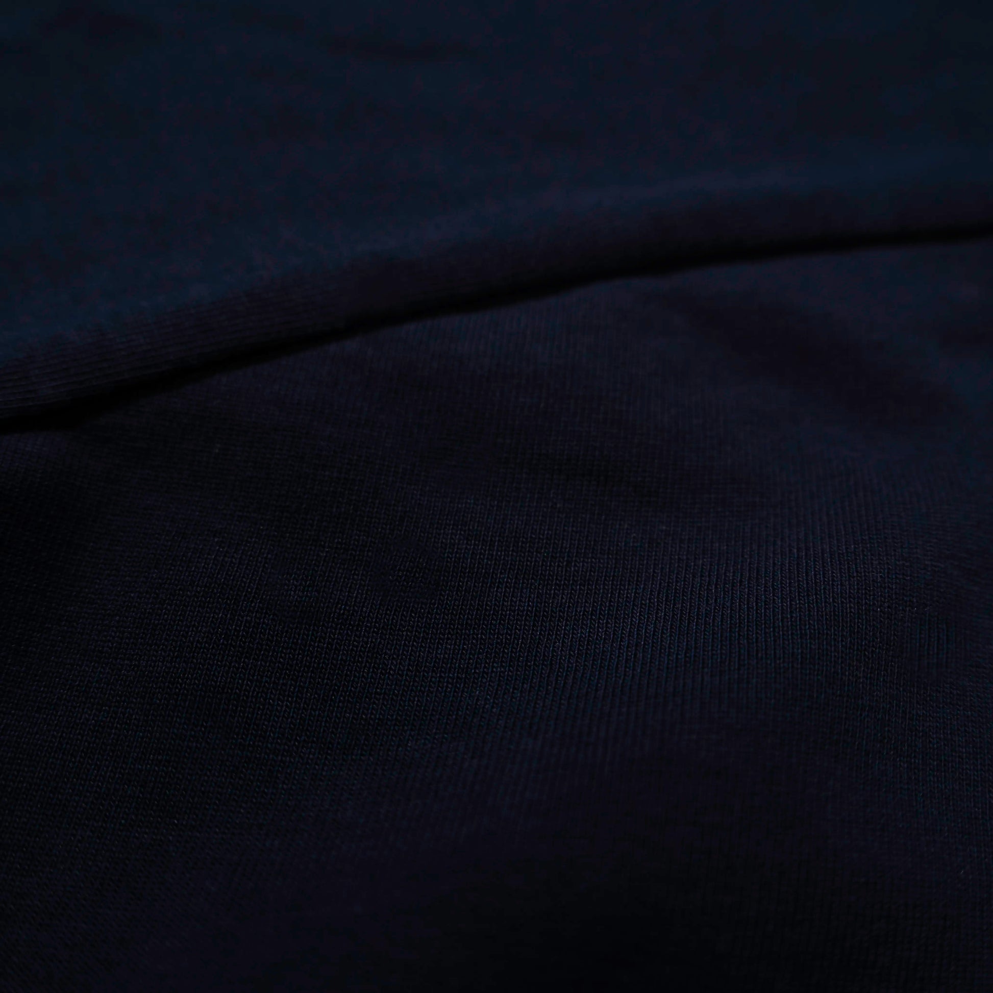 Fabric detail of dark navy 300gsm heavyweight 100% cotton from a pocket tee—durable streetwear.