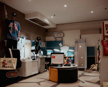 THAT’S RUFF pop-up in Sydney with an office-themed setup—mannequin, desks and computers showcasing tees, hats, pins and sticker sheets.